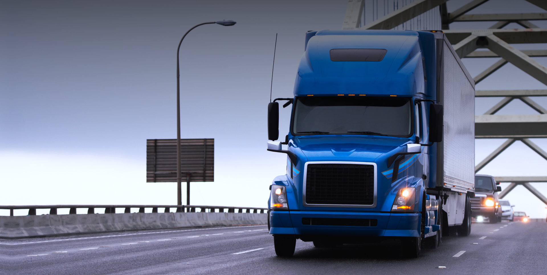 blue truck on a bridge
